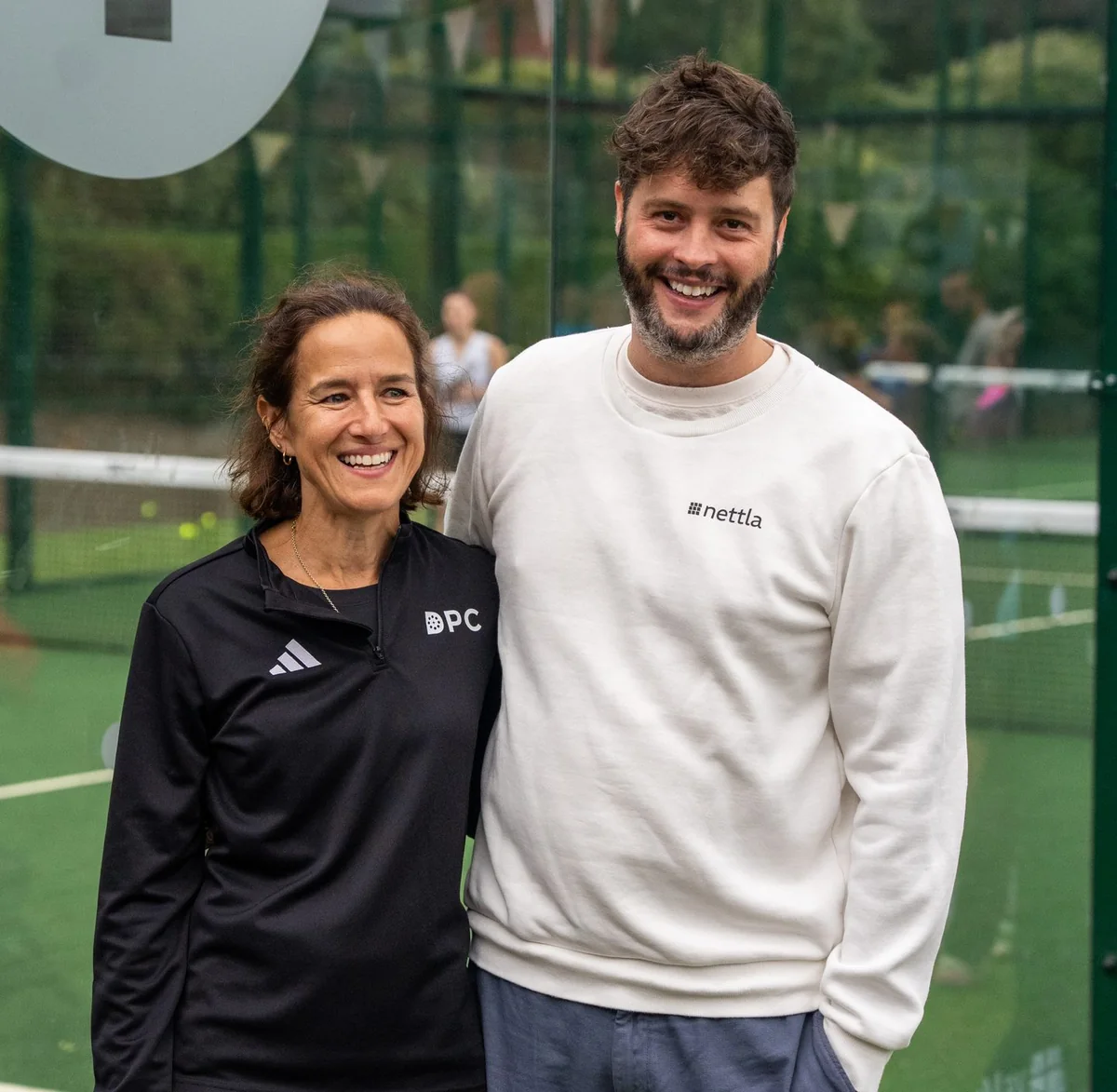 Two club founders smiling on court